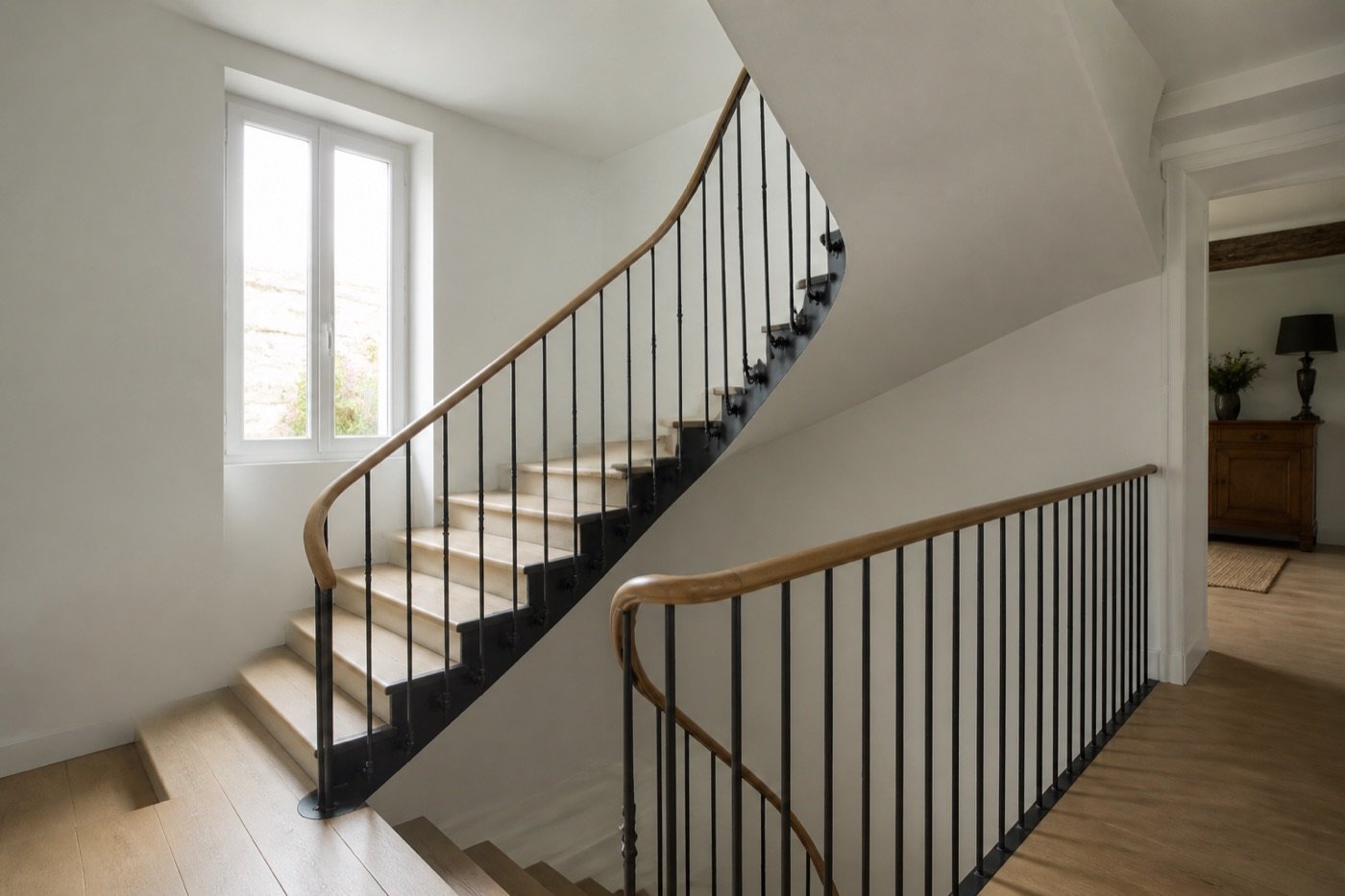 Escalier intérieur avec rambarde en acier noir et main courante en bois